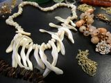many different necklaces and bracelets on a table
