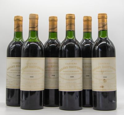 six bouteilles de vin sont alignées sur une surface blanche