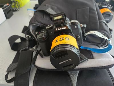 a camera sitting on top of a backpack on a table