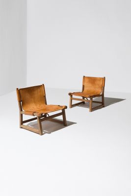 deux fauteuils en cuir marron dans une pièce blanche aux murs blancs