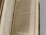 an open book on a table with a white table cloth