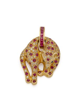 Gros plan sur un pendentif en forme d'éléphant en or et rubis, sur fond blanc