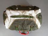 a green bag with a red handle hanging on the wall