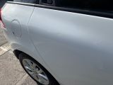 a small white car parked on the side of the street