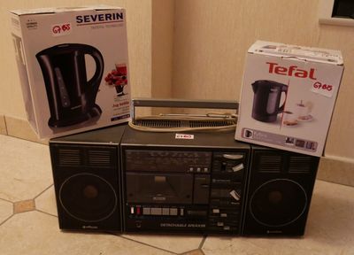deux boîtes posées sur une chaîne hi-fi posée à même le sol