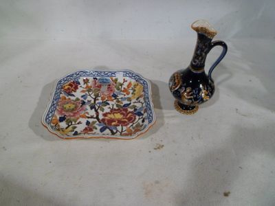 two vases and a plate sitting on a table