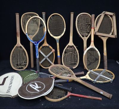 Plusieurs raquettes de tennis sont alignées sur un fond noir.