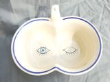 an apple shaped bowl with an eye drawn on it