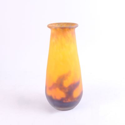 un vase jaune et noir posé sur une surface blanche