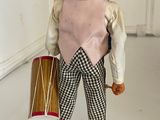 a figurine of a man with a hat and a drum