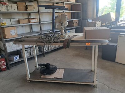 une table sur laquelle est posé un ventilateur, dans un garage