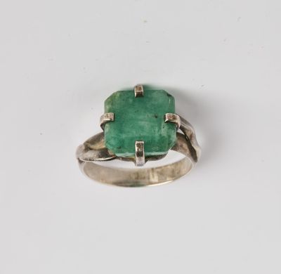 Gros plan sur une bague ornée d'une pierre verte