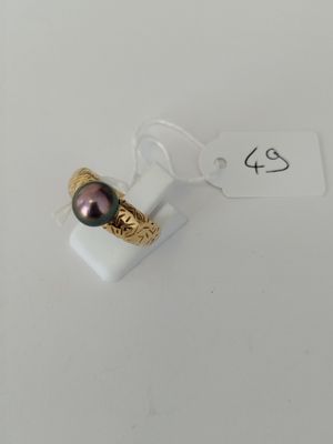 a close up of a ring with a black pearl on it