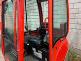 an image of a small excavator parked in front of a building
