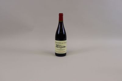 une bouteille de vin rouge posée sur une table blanche