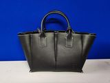 un sac à main en cuir noir posé sur une table blanche