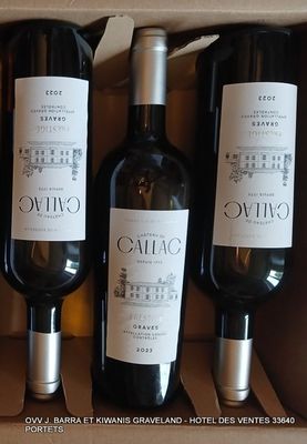 trois bouteilles de vin sont posées sur une table dans un carton