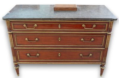 an antique chest of drawers with marble top and brass handles