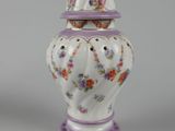 purple and white vase with flowers on it on a gray surface