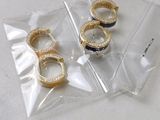 three gold rings are sitting on a clear plastic bag on a table