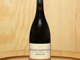une bouteille de vin posée sur un tonneau en bois