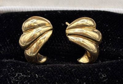 pair of gold tone earrings in a black velvet box