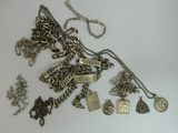 a lot of silver jewelry on a white surface