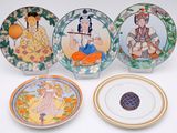four decorative plates with asian designs on them sitting on a white surface