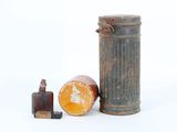 an old metal canister with a piece of orange next to it