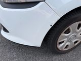 a close up of a white car parked in a parking lot