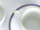 two cups and a saucer on a white table