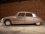 a tan car parked in a garage next to a brick wall