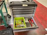 une boîte à outils contenant des outils, posée sur le sol