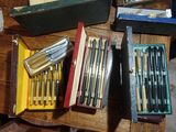 a lot of pens and pencils in a box on a table