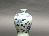 a blue and white vase sitting on a gray surface