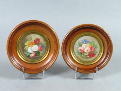 une paire d'assiettes en bois ornées de motifs floraux, exposées