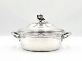 silver plated casserole with lid and handles on a white surface