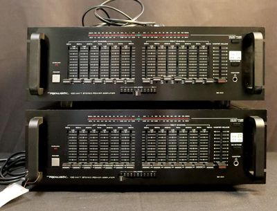 two black electronic equipment sitting on top of each other on a table