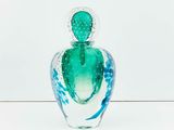 a glass vase with a cactus in it on a table