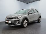 Une voiture grise est garée dans une grande pièce aux murs blancs.