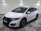 La Honda Civic blanche est garée sur un sol carrelé à damier.