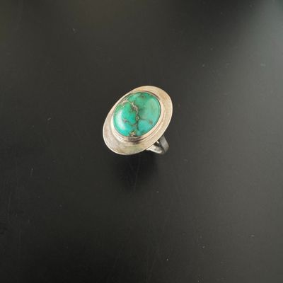 une bague en argent ornée d'une turquoise au centre