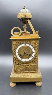 a gold clock that is sitting on a table