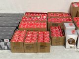 Plusieurs cartons de sodas sont empilés les uns sur les autres sur une table