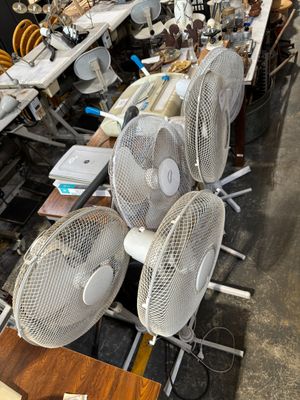 de nombreux ventilateurs posés sur une table dans une pièce