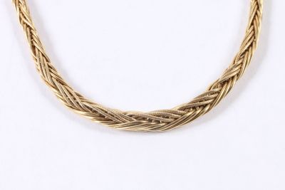 gros plan d'un collier en or sur fond blanc