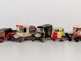 many toy cars lined up in a row on a white surface