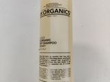a bottle of organics shampoo on a white surface
