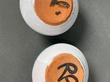 pair of white and orange vases with chinese writing on them