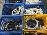 many baskets filled with wires and cords on the floor